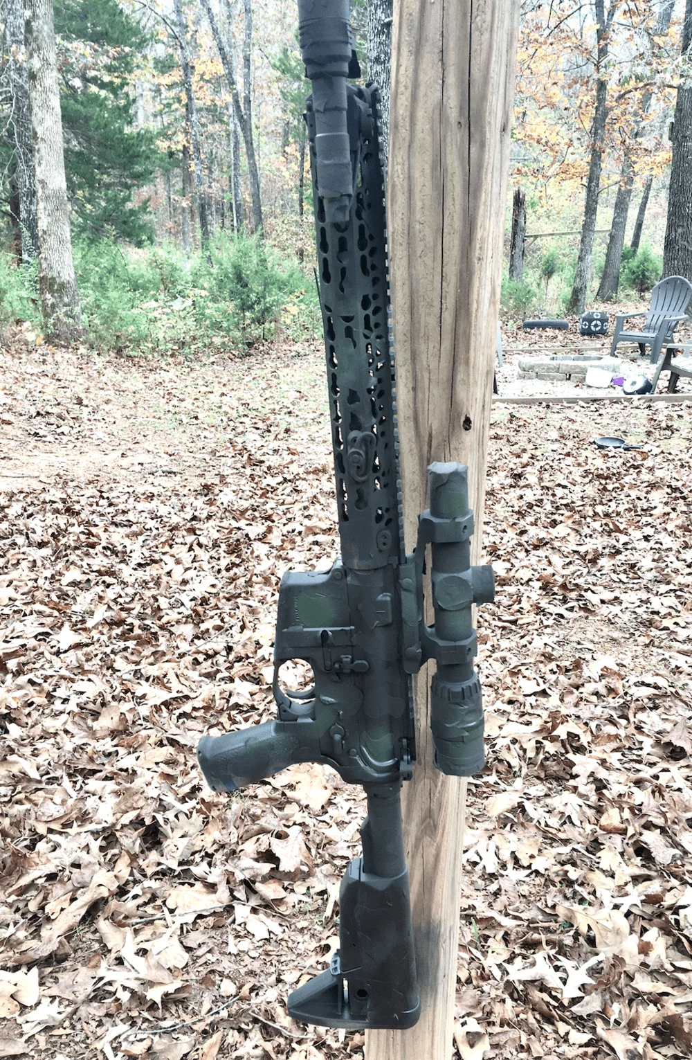 camo ar15 hanging on post for spray painting