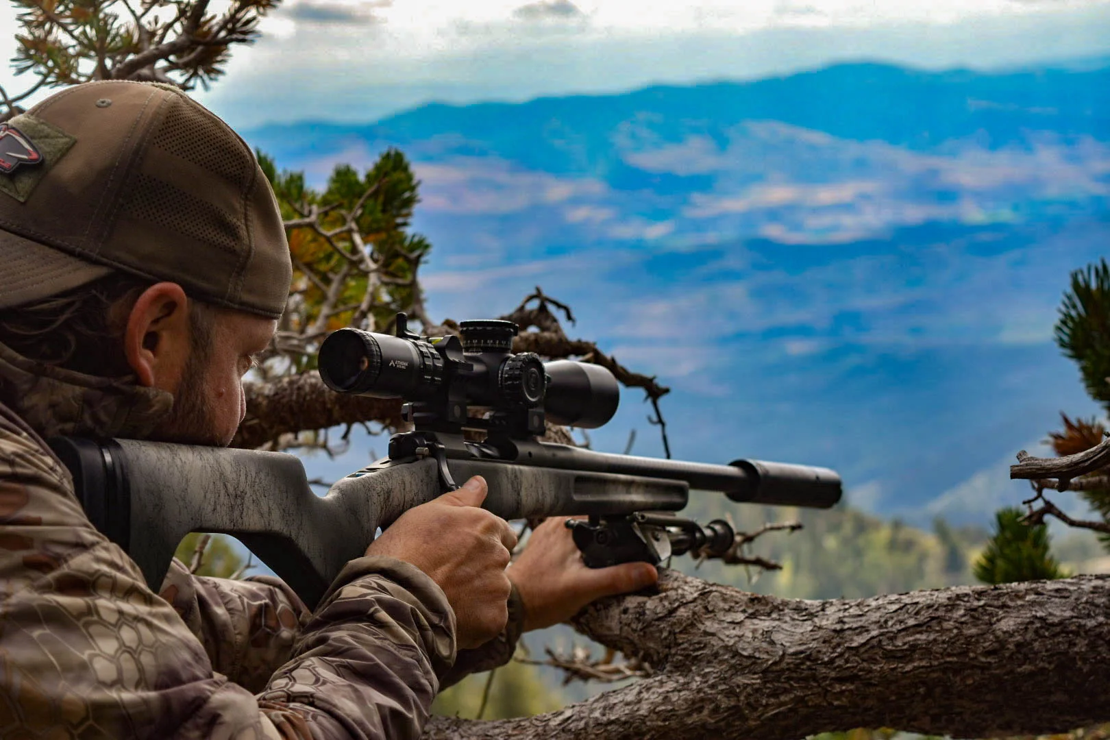 A person hiking in mountainous terrain carrying the Springfield Armory Model 2020 Redline rifle