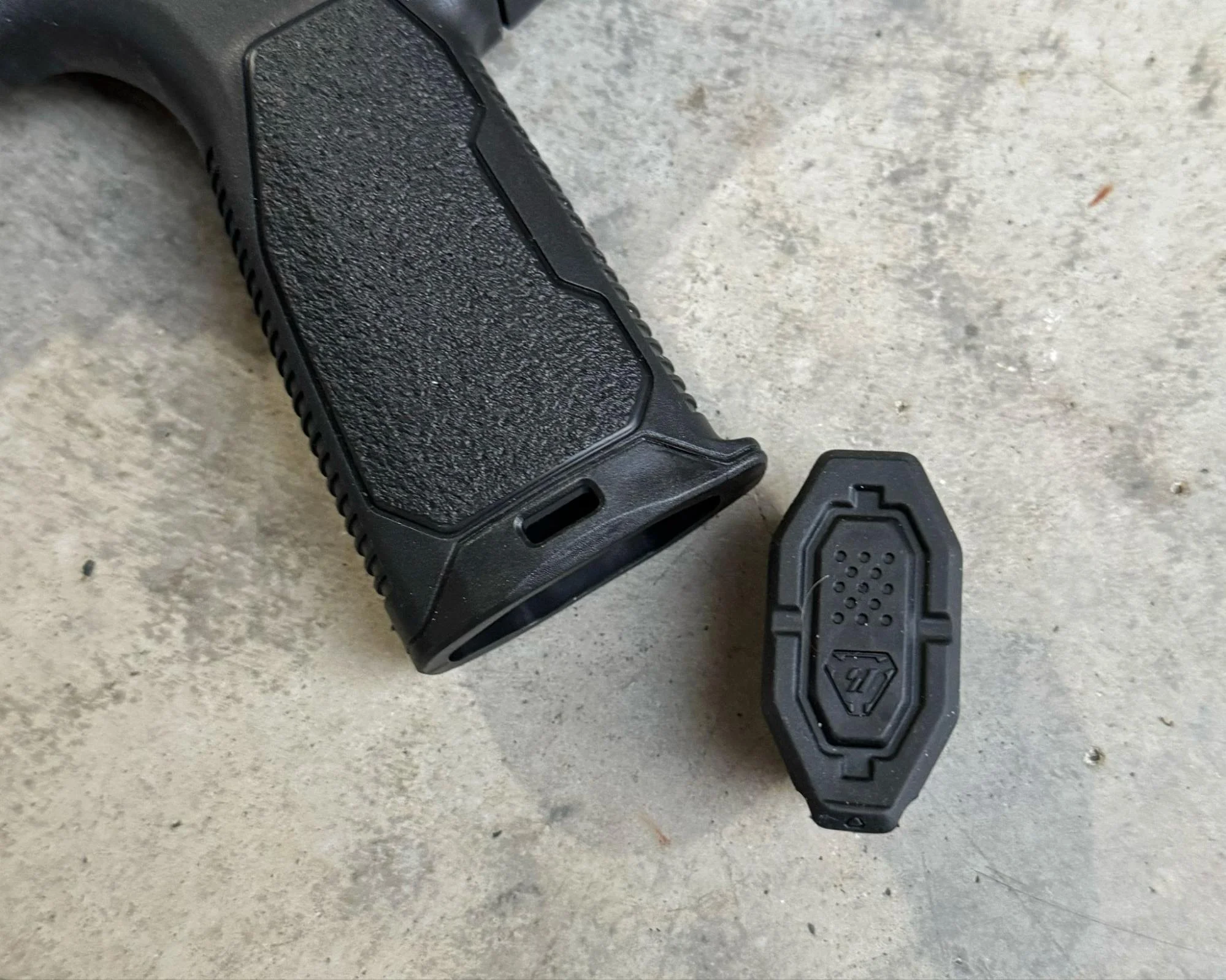 An image showing the fully removable rubber end cap on a Strike Industries AR grip, contrasting it with traditional latch designs