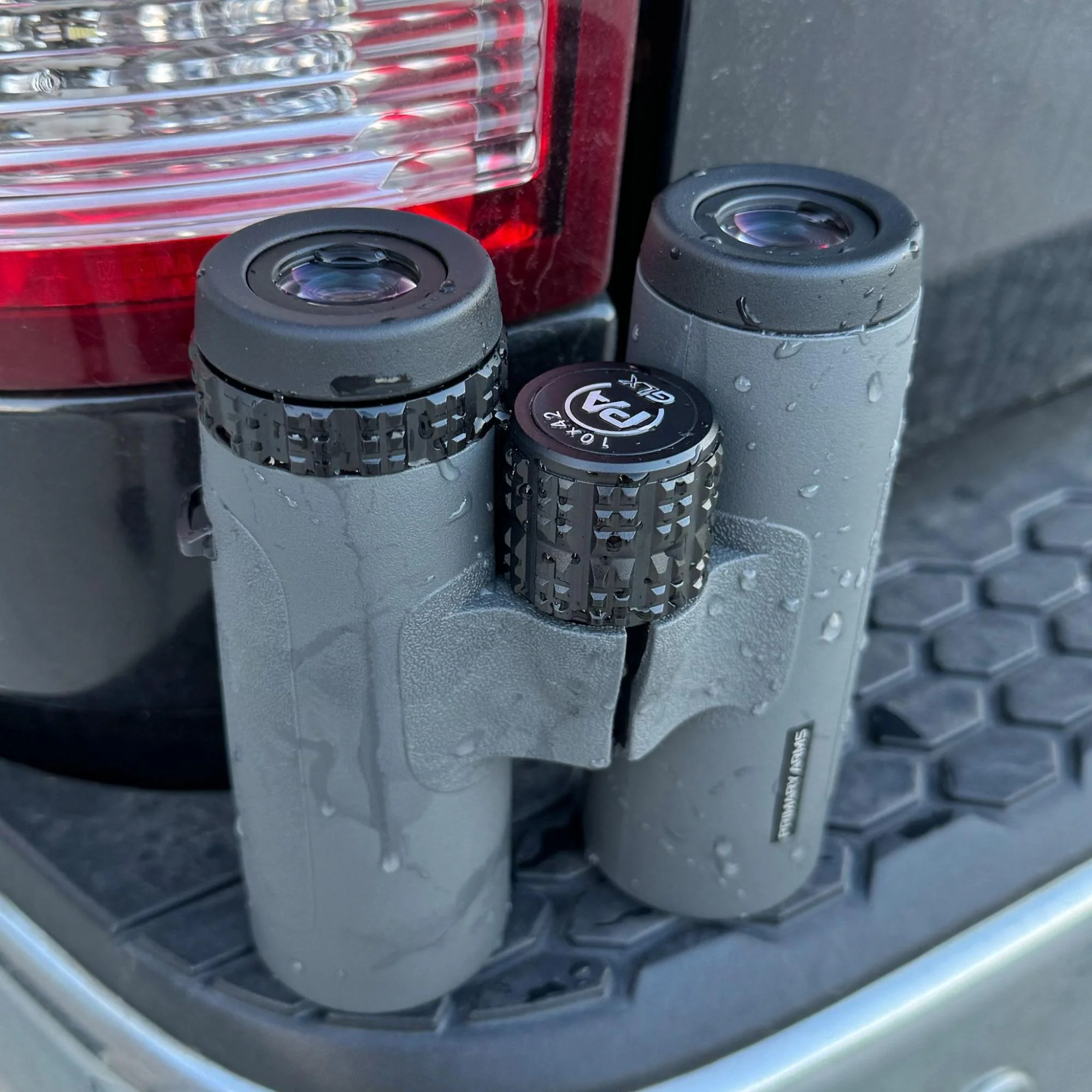 GLx binoculars being tested in wet conditions, showing their waterproof capabilities