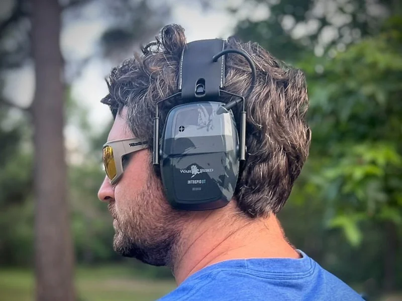 Person at the shooting range wearing safety glasses and hearing protection.