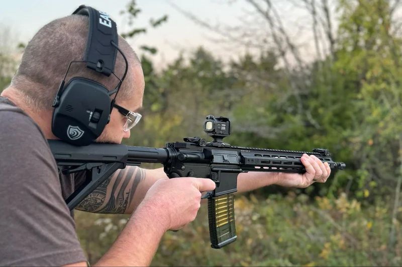 Aimpoint Acro C-2 optic mounted on a carbine with a new TMAG magazine nearby