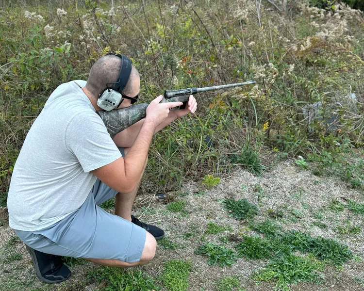 Shooter holding the compact Henry Survival Rifle during testing at the range