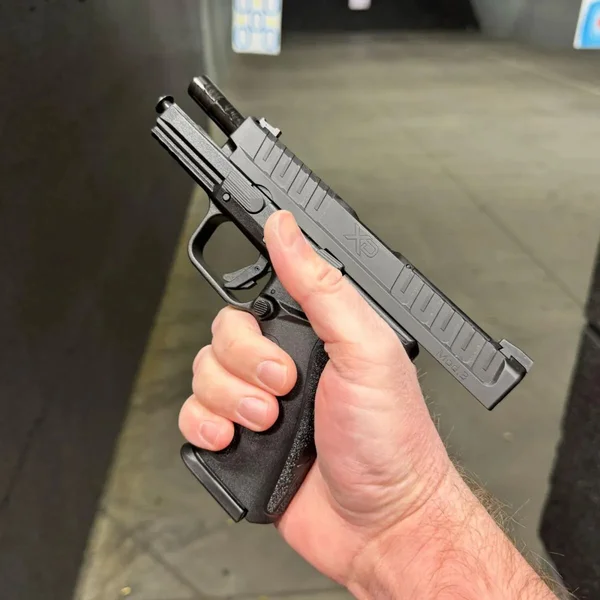 A shooter holding the XD Mod.3 pistol, demonstrating grip ergonomics