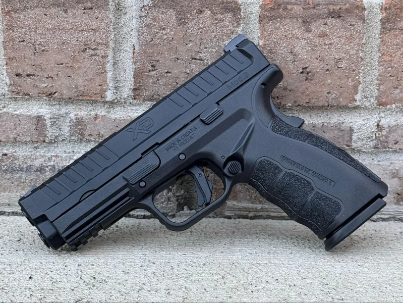 XD Mod.3 resting on a shooting range table, with spent casings around it