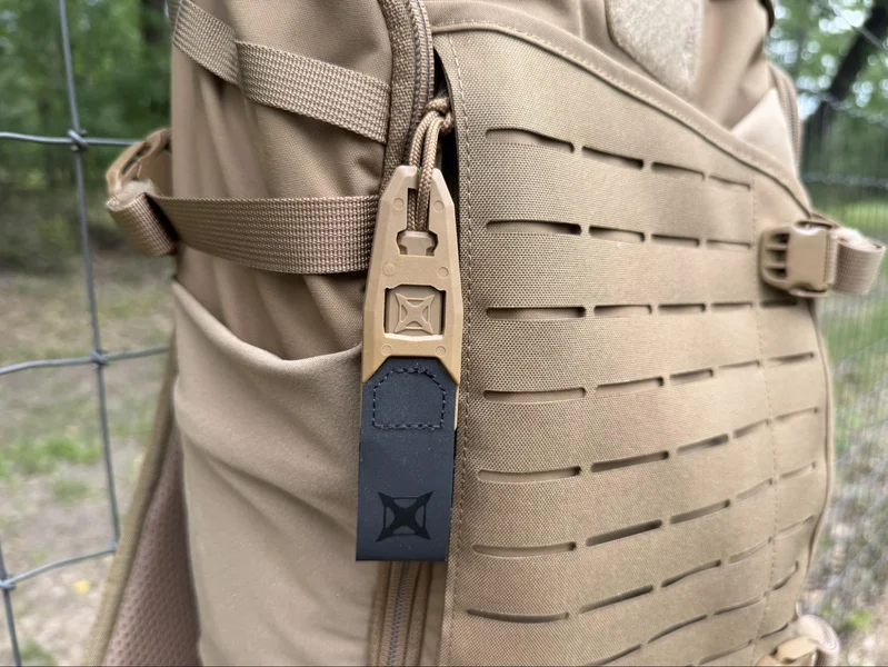 Close-up of the Vertx Siege 25L backpack’s Rapid Access Half-Pull tab and MOLLE webbing, highlighting ease of access and tactical design.