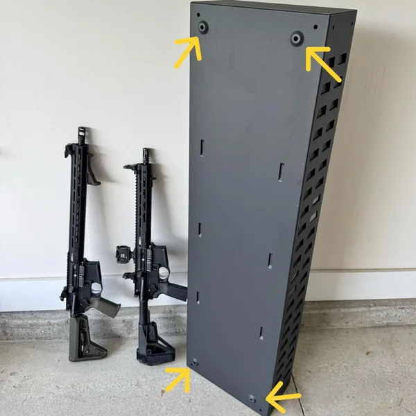 Rear view of vertically positioned SecureIt Model 47 safe with visible pre-drilled mounting holes and two rifles standing nearby