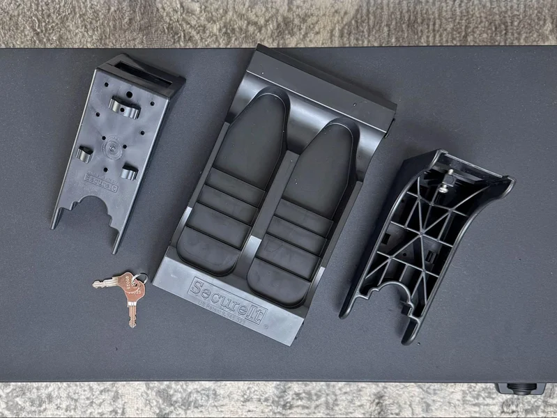 SecureIt Fast Box Model 47 accessories including two cradle components, a dual buttstock base, and a set of backup keys laid out on top of the safe.