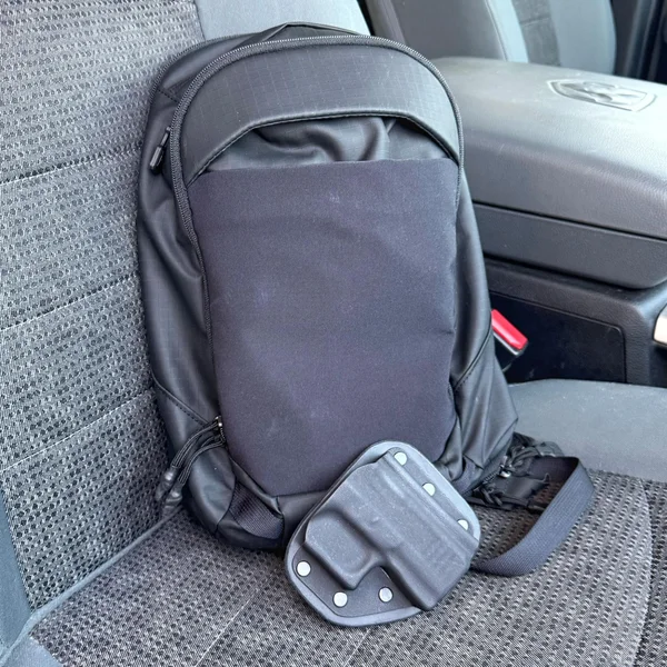 VERTX Urban Ghost Sling Bag with a CrossBreed Holster placed on a car seat