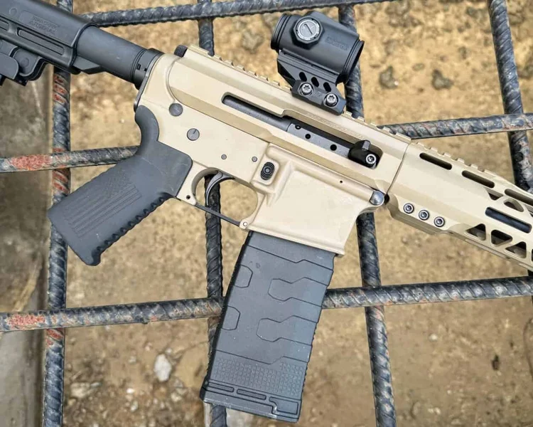 Close-up of side-charging Flat Dark Earth BC-15 AR-15 with black furniture and optic