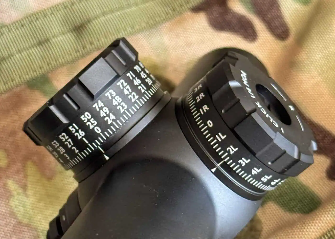 Detailed view of the GUNNR Odin LPVO locking turrets and zero-stop feature on a camouflage background