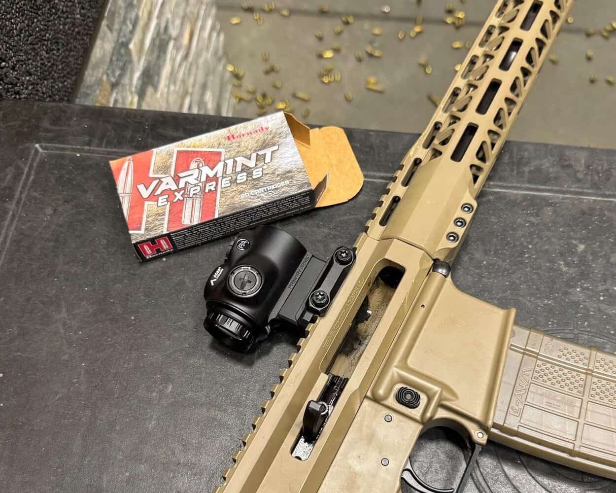 FDE rifle with GLx 1x optic resting on shooting mat with Hornady ammo box beside it.