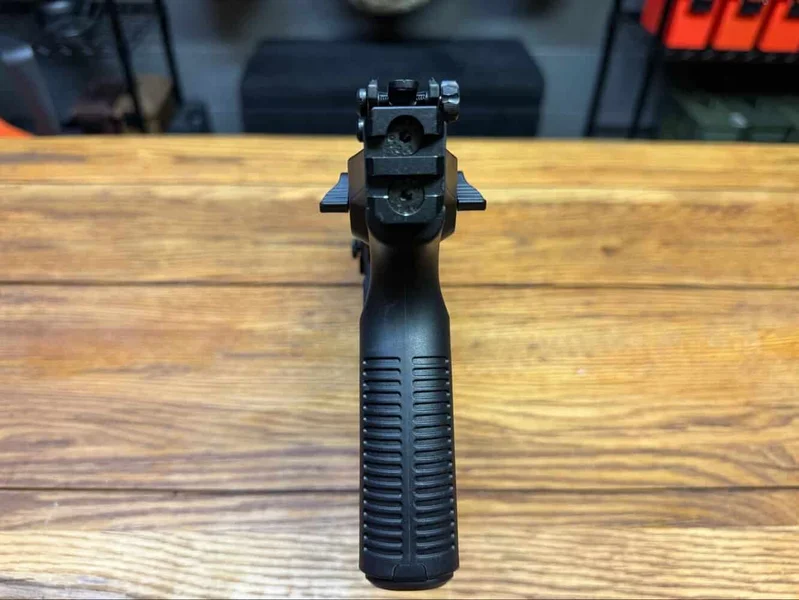 Rear view of Kriss Vector Gen 3 showing Picatinny end rail and sights mounted, positioned on a wooden surface.