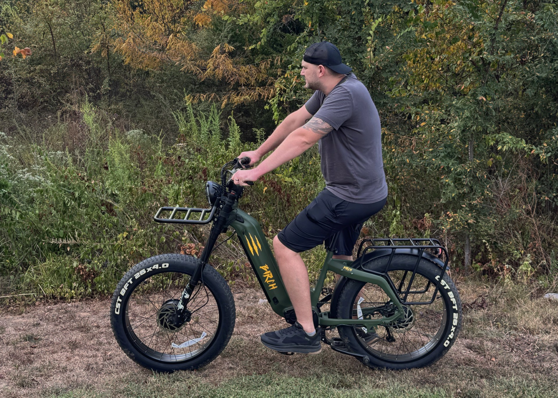 Rider on Birch Grolar AWD hunting bike navigating through grass and brush, demonstrating off-road capability and stability.