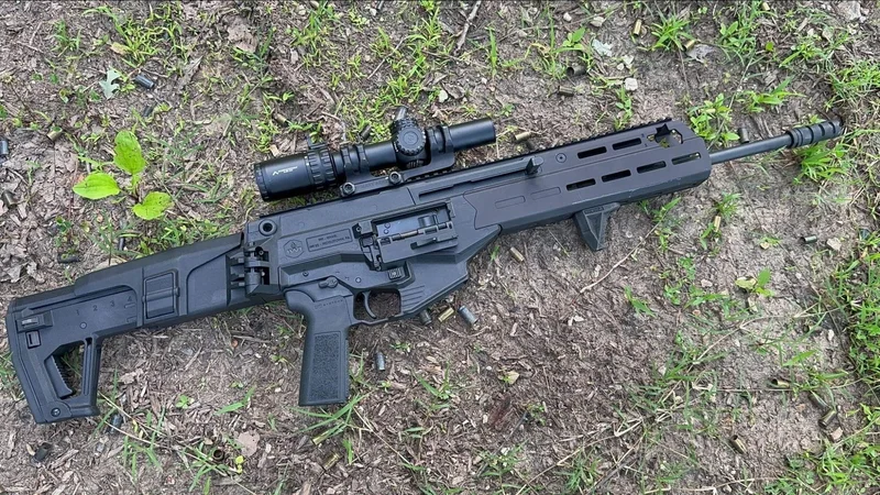 IWI Carmel rifle with mounted optic lying on the ground after live fire testing at the range