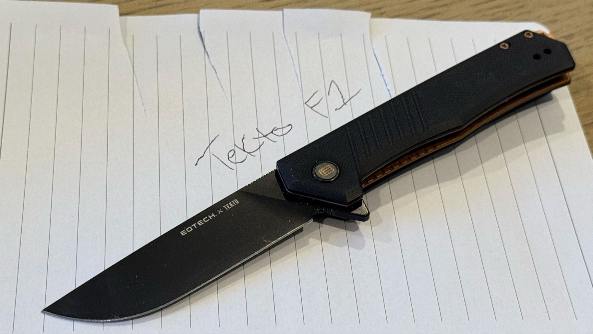 Tekto F1 Alpha EOTECH knife shown on paper with cut marks and handwritten 'Tekto F1' text
