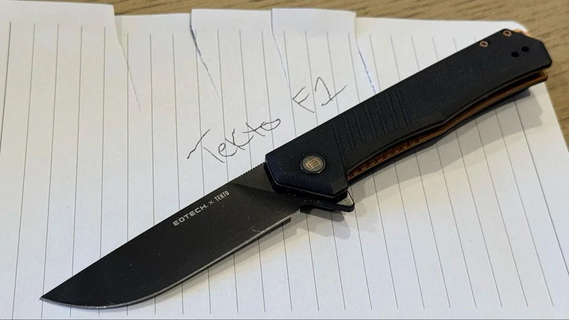Tekto F1 Alpha EOTECH knife shown on paper with cut marks and handwritten 'Tekto F1' text