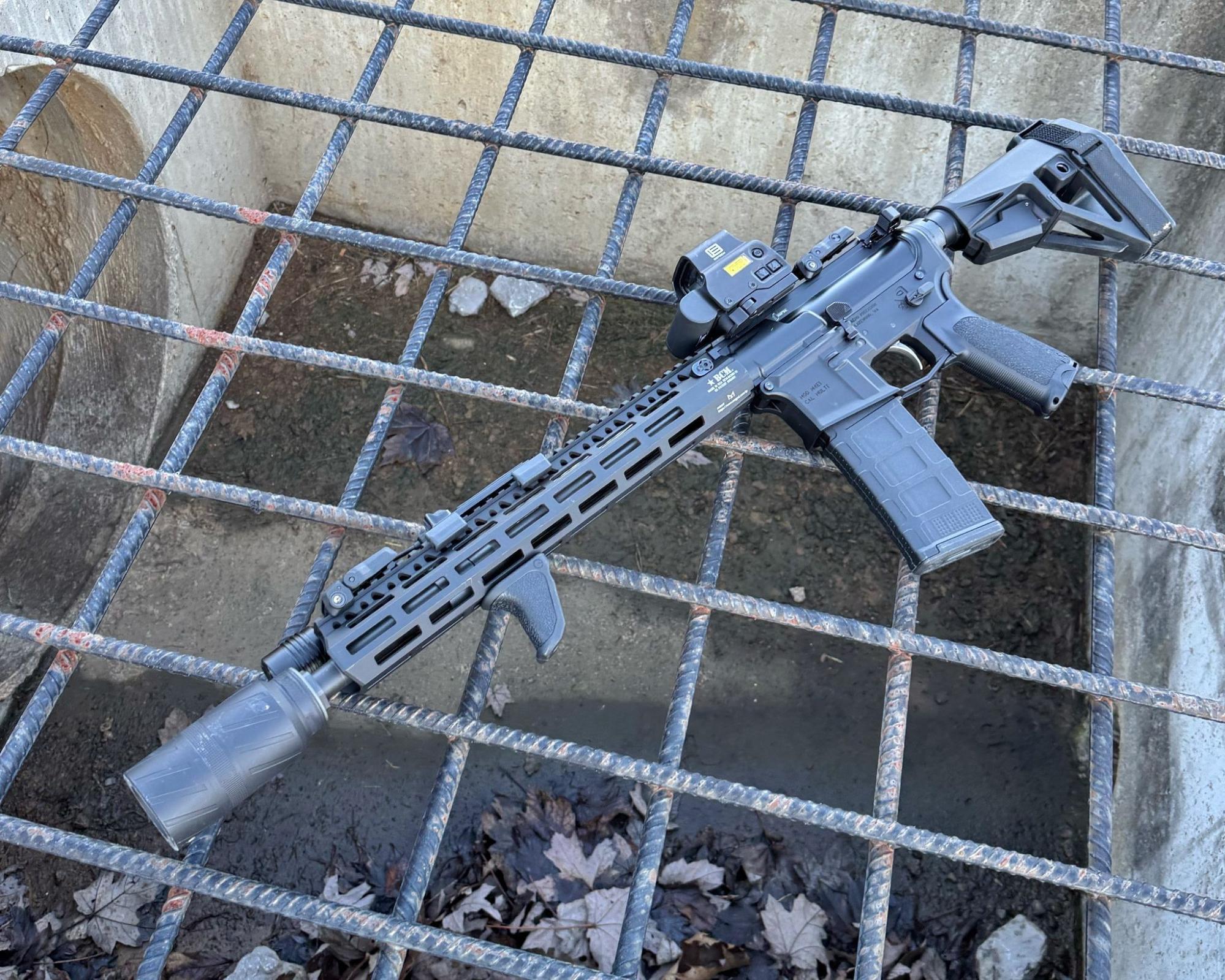 AR-15 rifle equipped with BANISH Speed K suppressor resting on metal grate