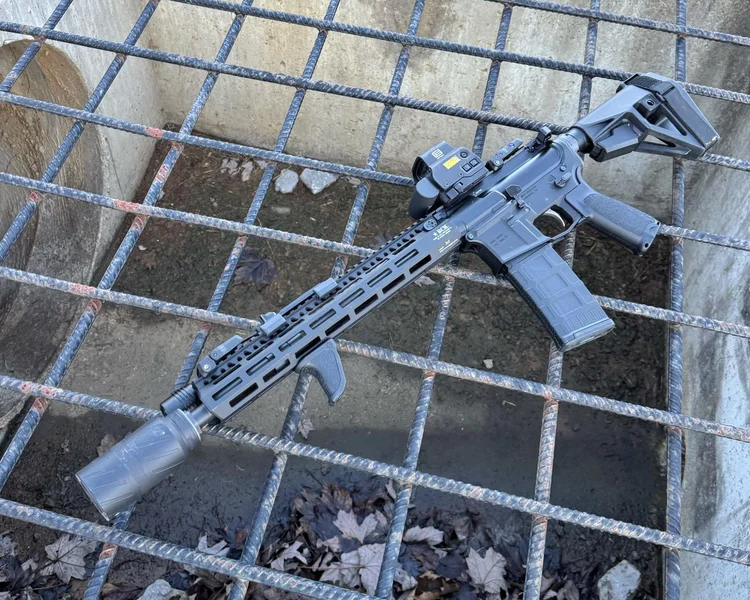 AR-15 rifle equipped with BANISH Speed K suppressor resting on metal grate