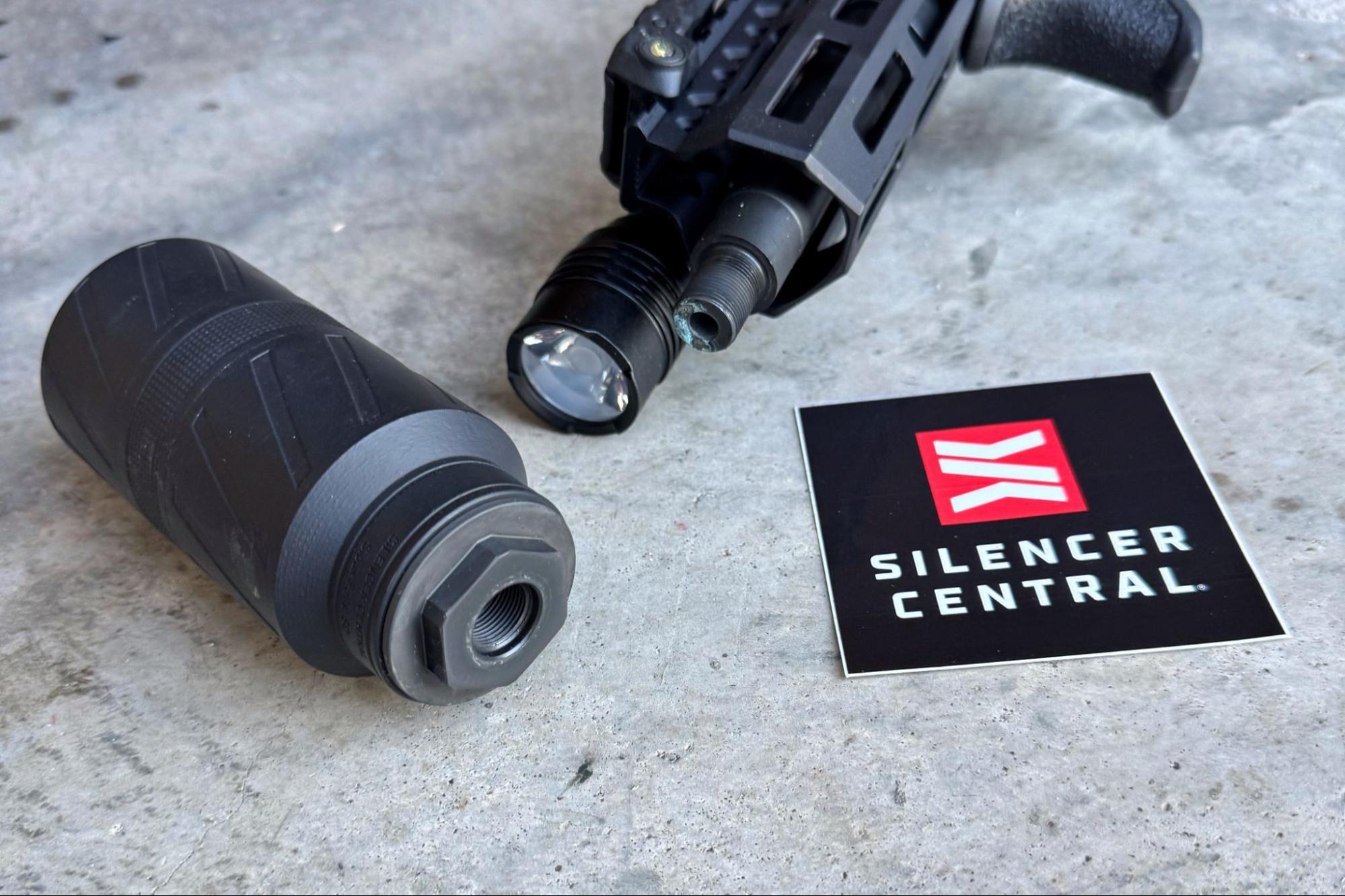 BANISH Speed K suppressor detached from AR-15 with Silencer Central logo on concrete surface