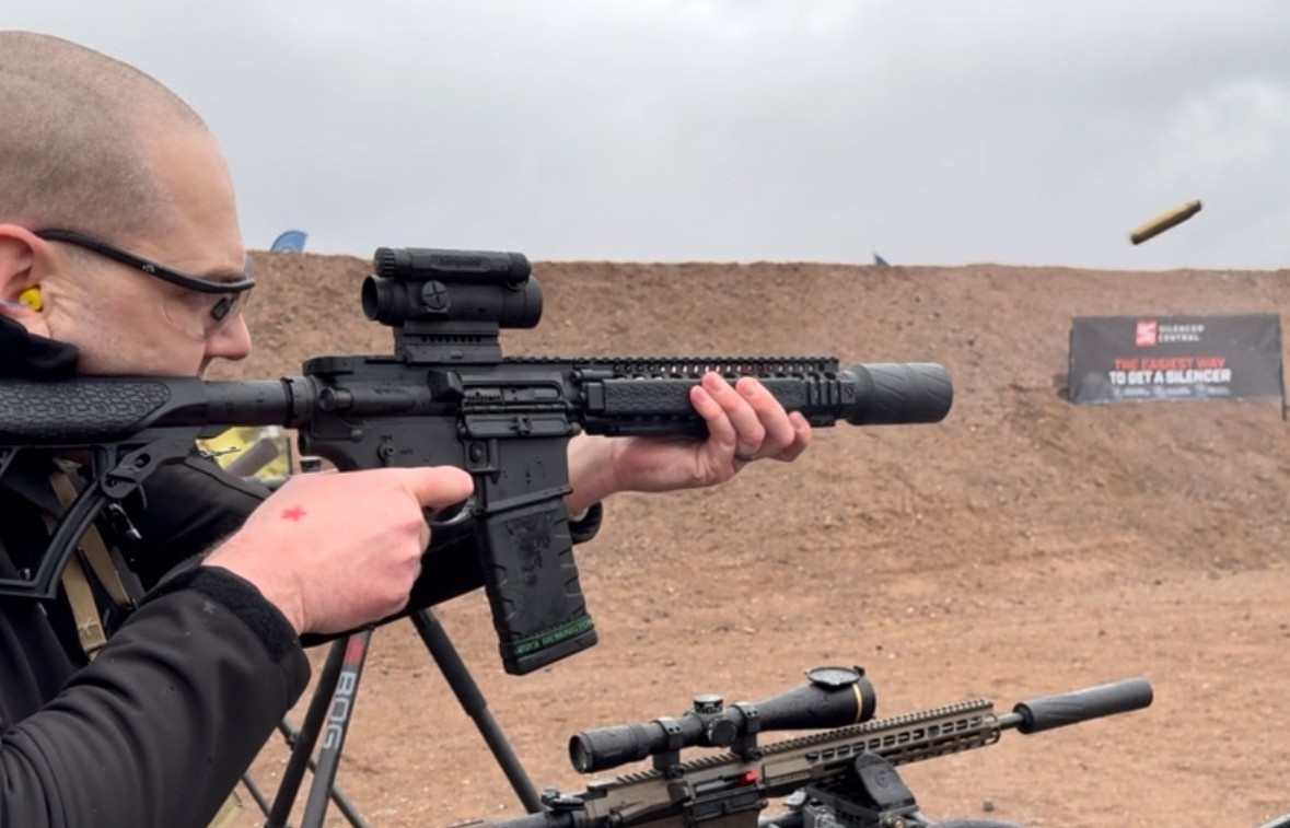 Man shooting AR-15 with BANISH Speed K suppressor at outdoor gun range