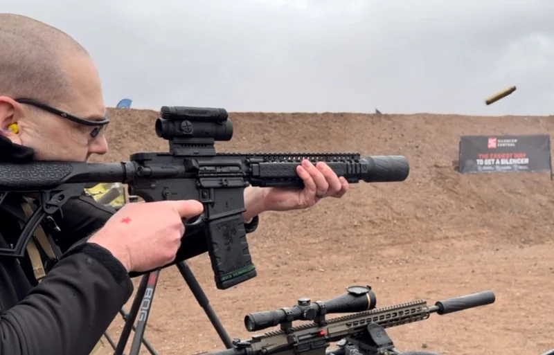 Man shooting AR-15 with BANISH Speed K suppressor at outdoor gun range