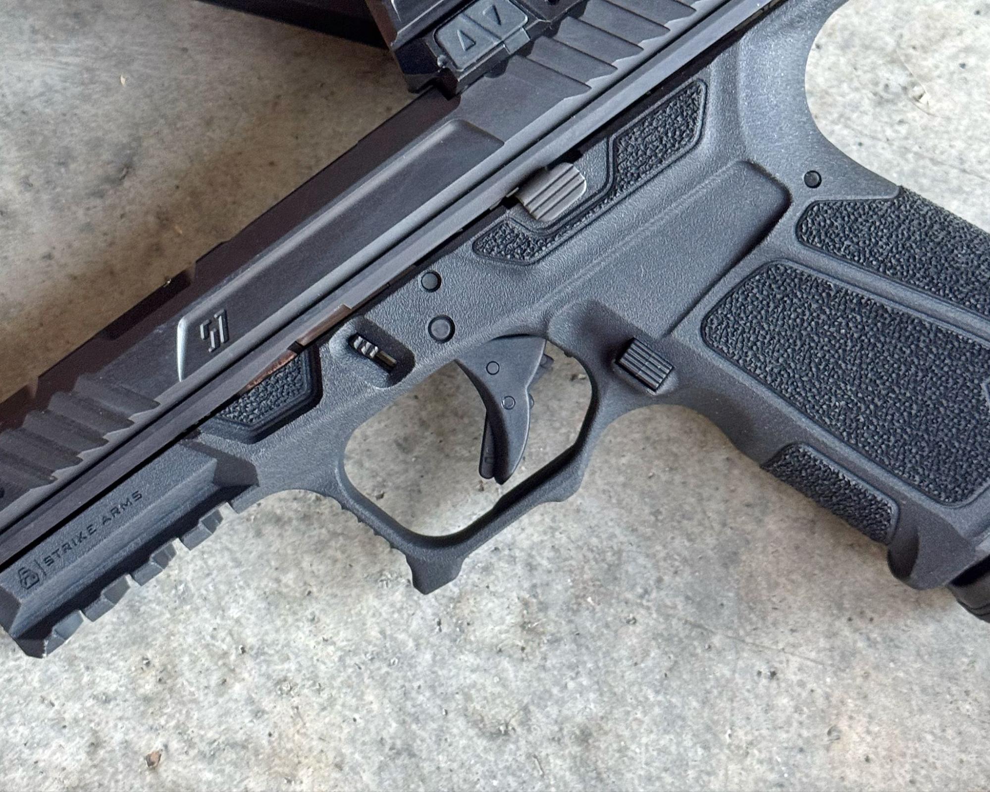 Detailed view of the unique trigger guard cuts and sizable undercut on the Strike Arms frame.