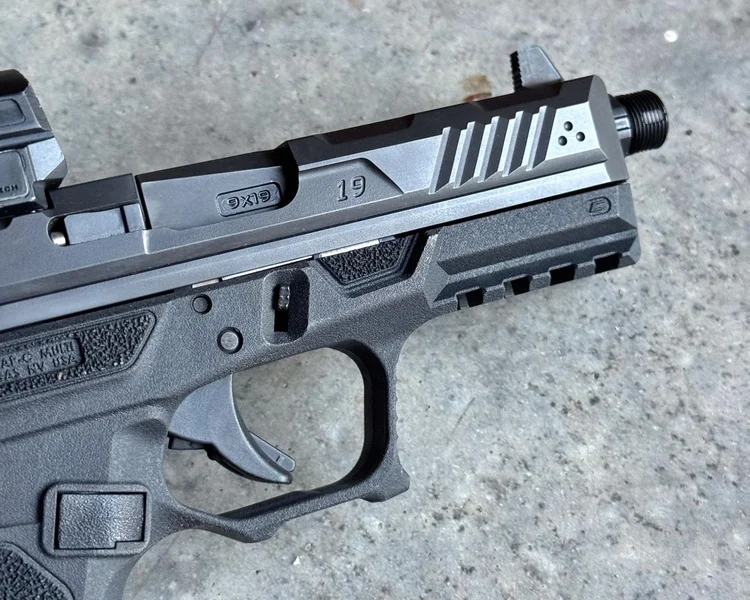 Strike Arms pistol slide featuring front serrations and a dedicated thumb rest recess for improved control.