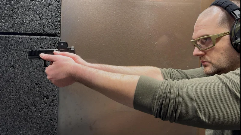 The reviewer firing the Glock 19 Gen6 at an indoor shooting range during the 600-round reliability test