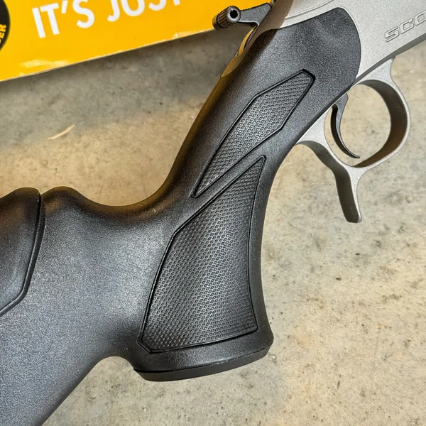 Close-up of the CVA Scout TD pistol grip texturing and the ambidextrous hammer extension for scope clearance