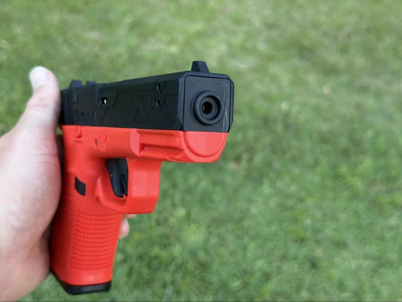 Front angle of the Mantis TitanX training pistol showing the integrated laser aperture for immediate shot feedback