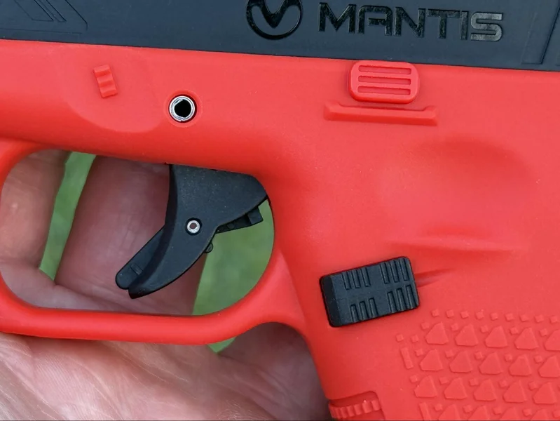 Macro view of the Mantis TitanX trigger and magazine release, designed to mirror the ergonomics of a Glock 19 footprin